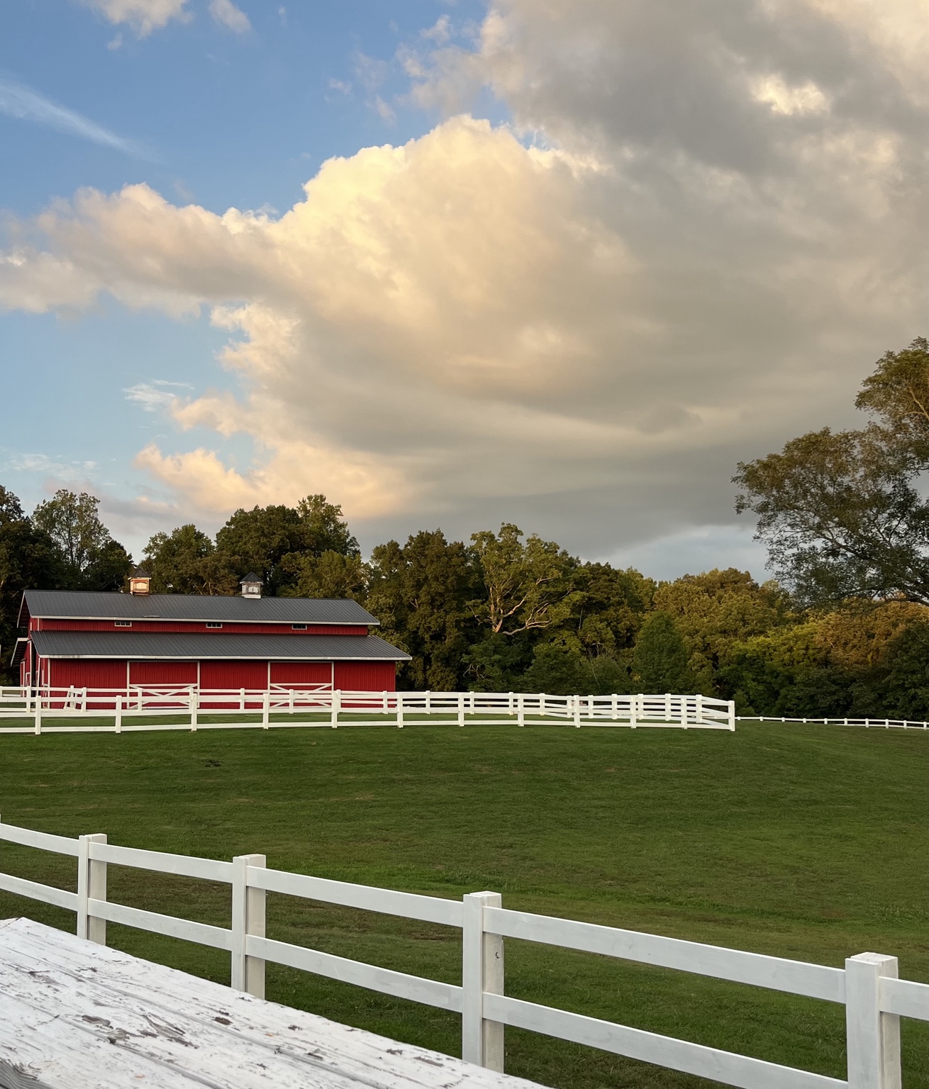 Sterling Hills barn, white fencing, and open green pasture