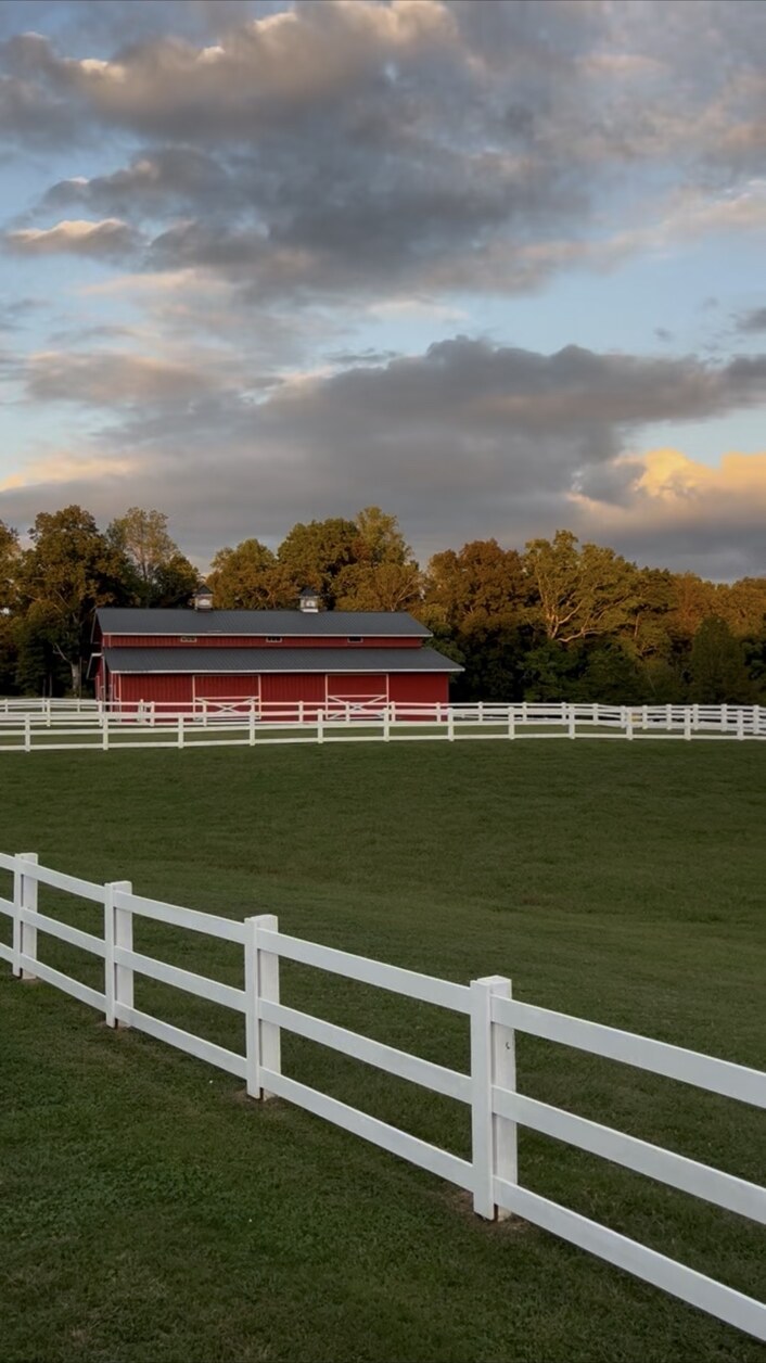 Sterling Hills barn and white fencing in warm evening light