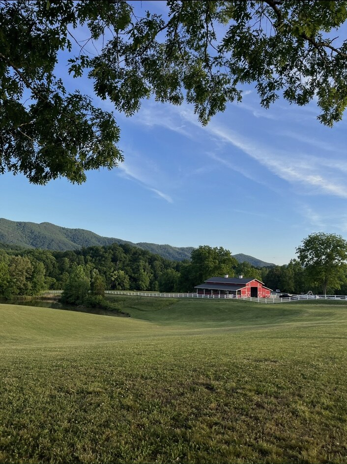The Sterling Hills barn across rolling fields beneath the Smoky Mountains