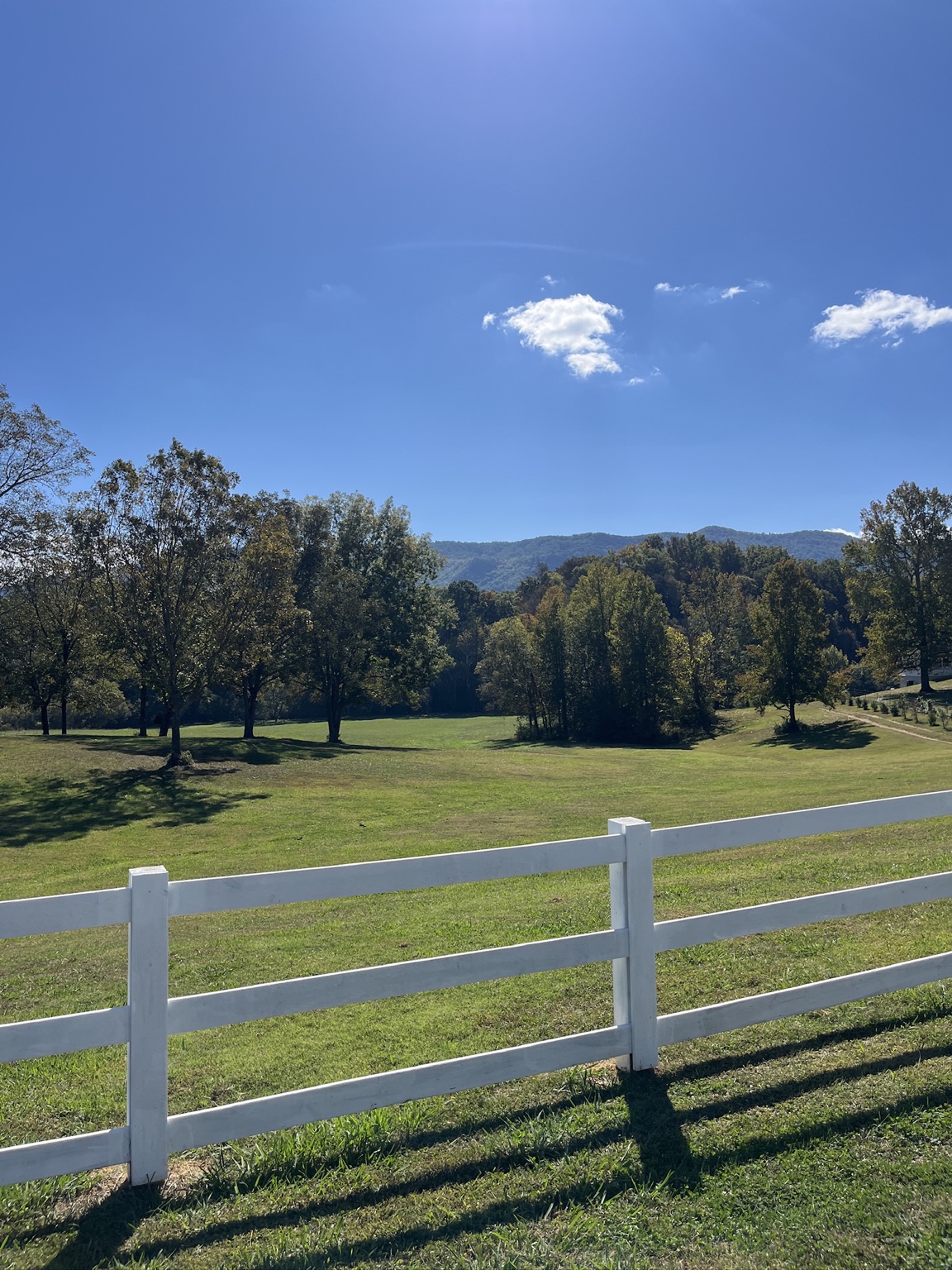 Open green fields, white fencing, and Smoky Mountain views at Sterling Hills